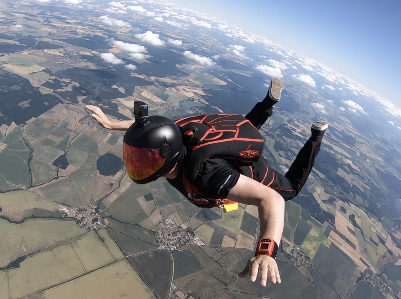 Ein Fallschirmspringer im freien Fall über Feldern
