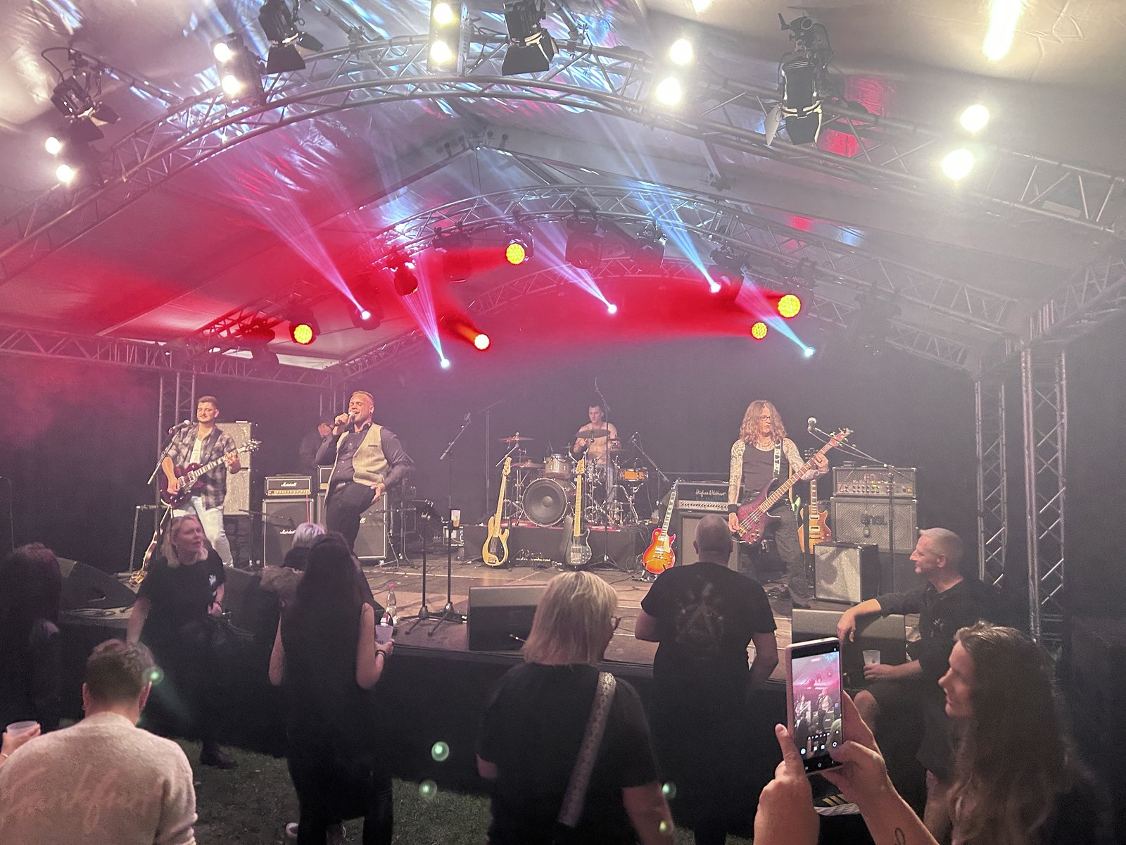 Band und Publikum unter rotem und blauem Bühnenlicht im Festzelt