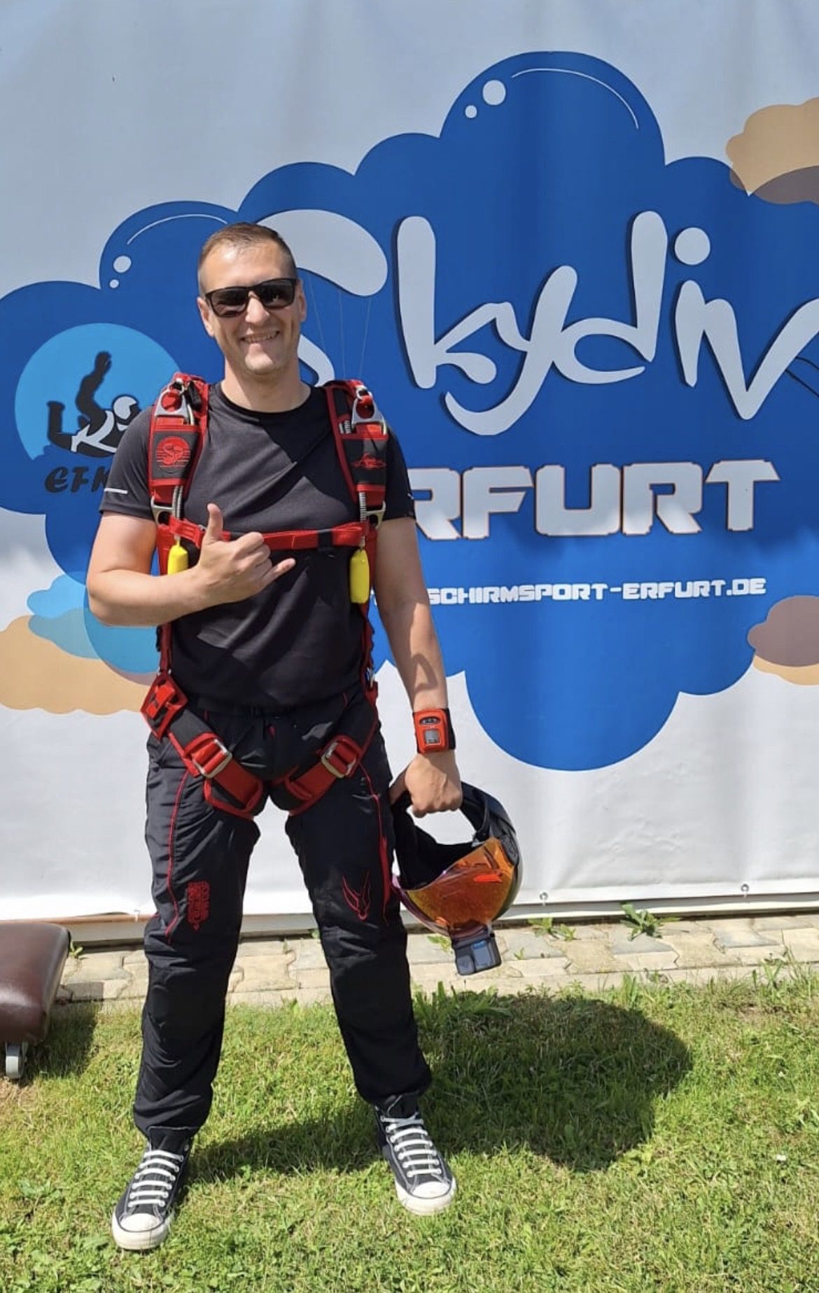 René Bringezu in Sprungausrüstung vor dem Banner von Skydive Erfurt